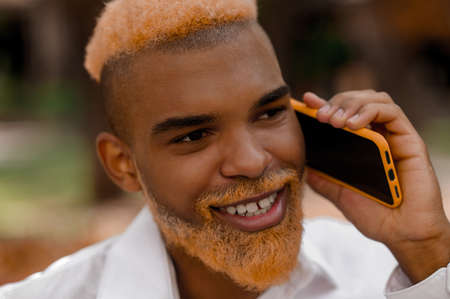 A positive good-looking stylish man with a smartphoneの写真素材