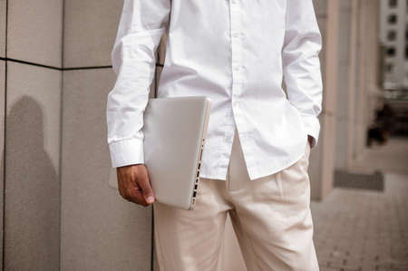 Close up picture of a man in hite suit with a laptopの写真素材