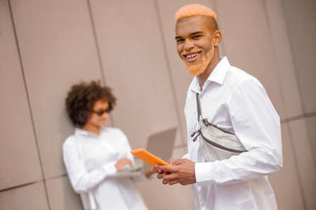 Two people with electronic devices in the streetの写真素材