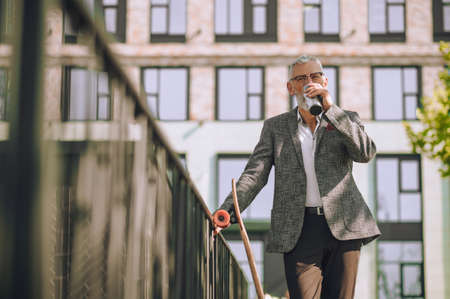 A man in an elegant jacket with a bottle in hand