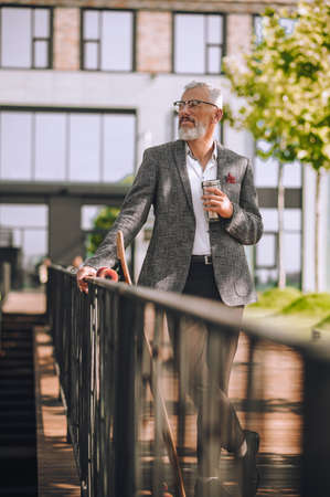 A man in an elegant jacket with a bottle in handの写真素材