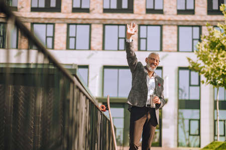 A mature man standing in the yard near the offcie buildingの写真素材