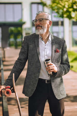A mature man with a spill-proof cup in handsの写真素材