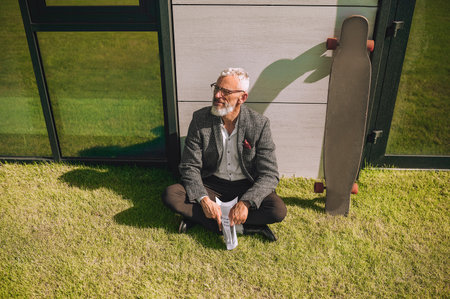 A mid aged man with a newspaper in hands looking thoughtfulの写真素材