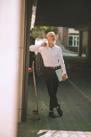 Stylish mature entrepreneur in eyeglasses looking awayの写真素材