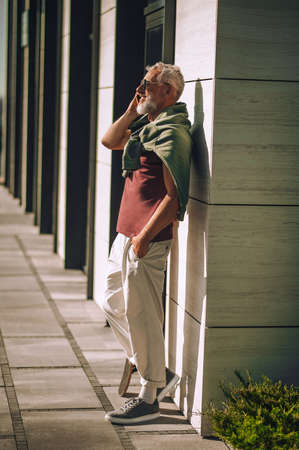 Cheerful mature man chatting on the cellphone outdoorsの写真素材