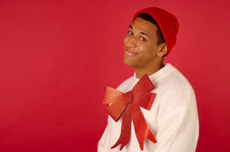 Dark-skinned man with a red ribbon on red backgroundの写真素材