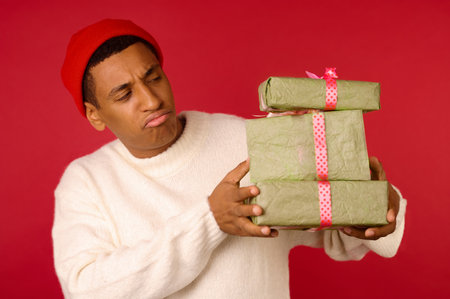 Young guy in santa hat holding giftsの写真素材