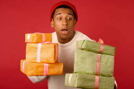 Young guy in santa hat holding giftsの写真素材