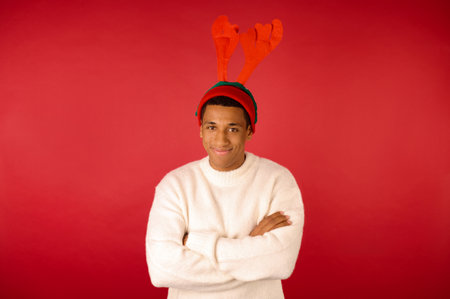 A man in swhites sweater and with reindeer antlersの写真素材