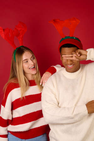 Two young people in horned hats on red backgroundの写真素材