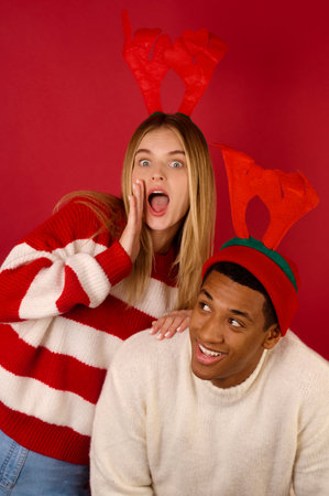 Two young people in horned hats on red backgroundの写真素材