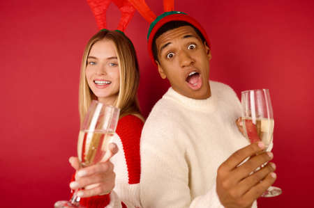 Young people in horned hats with glasses with champagneの写真素材