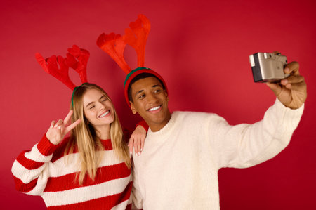 A happy young couple in horned hats making selfieの写真素材