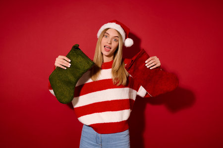 A girl in santa hat holding christmas stockingsの写真素材