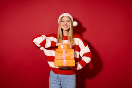 A girl in striped sweater holding many gift boxesの写真素材