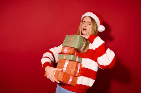 A girl insanta hat carrying lots of gift boxes