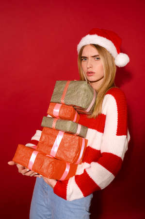 A girl insanta hat carrying lots of gift boxes