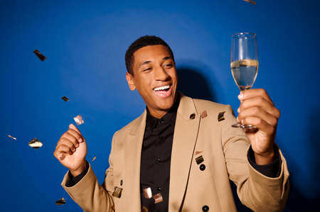 A good-looking young man holding a glass of champagneの写真素材