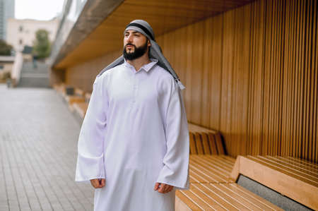 Middle eastern young man in traditional clothing walking along the streetの写真素材