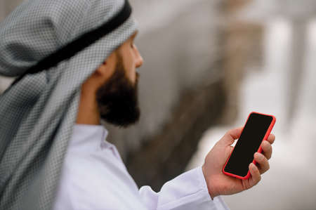 Arabian man with a smartphone in handsの写真素材
