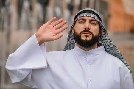 A man in traditional arabian clothing waving his handの写真素材