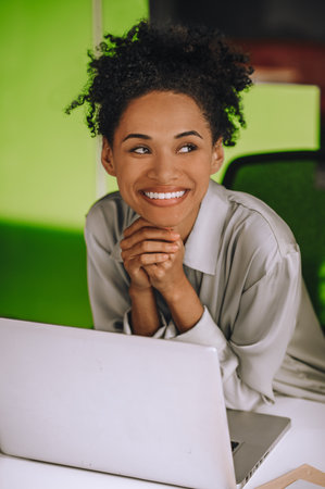 Young black woman at her working place in the office