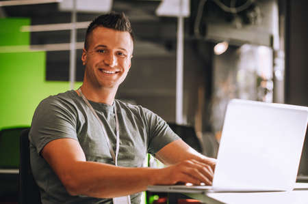 Short-haired young guy sitting at the laptop