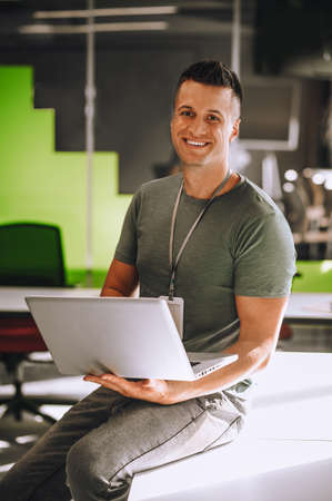Young man sitting on the table with a laptop