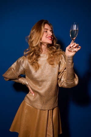 Girl solemnly looking at glass of champagne in handの写真素材