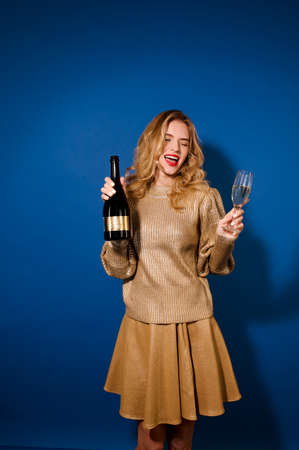 Beautiful girl with bottle of champagne and glassの写真素材