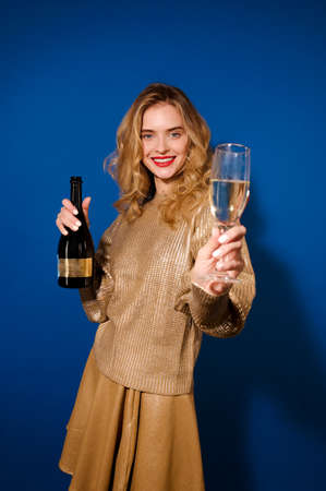 Girl with champagne holding out glass to cameraの写真素材