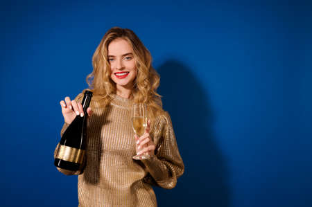 Girl looking at camera holding bottle of champagneの写真素材