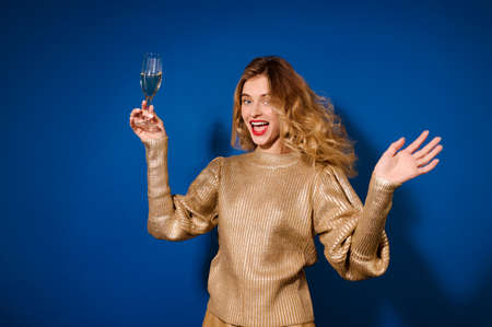 Emotional girl with glass of champagne in raised handの写真素材