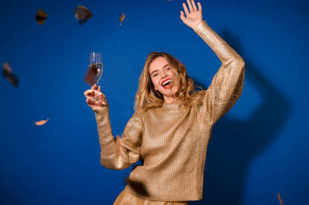 Happy girl raising her hand with glassの写真素材