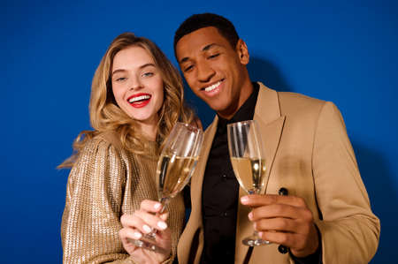Smiling girl and guy holding glasses of champagneの写真素材