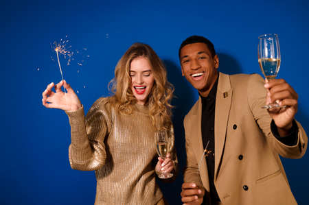 Girl and guy with champagne and burning sparklersの写真素材