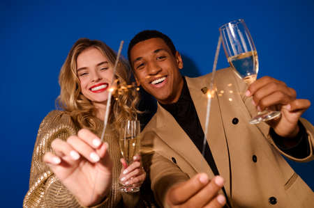 Guy and girl holding glasses of champagne to cameraの写真素材