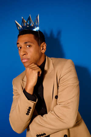 Dark-skinned in crown looking pensively at cameraの写真素材
