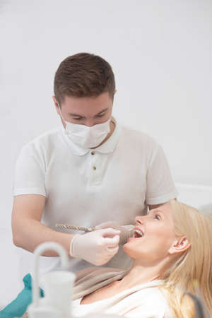 A male doctor in a protective mask working with a female patientの写真素材