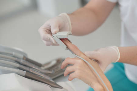 Close up of doctors hands with pulsometer