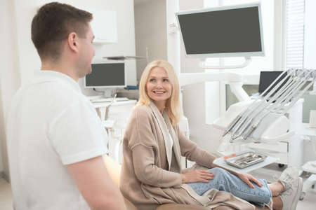 Happy doctor and his patient after the dental surgery