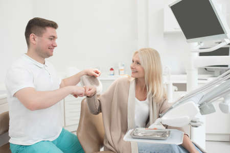 Happy doctor and his patient after the dental surgeryの写真素材