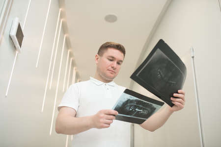 A male doctor scrutinizing xray results and looking seriousの写真素材