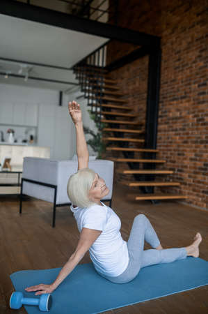 Woman in white tshirt and leggins doing stretchingの写真素材