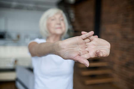 Woman in a white tshirt stretching her arms forwardの写真素材
