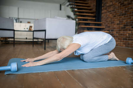 A woman laying on the floor in a child poseの写真素材