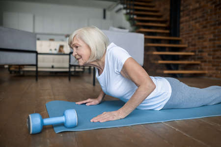 Senior active woman in a white tshirt doing plankの写真素材