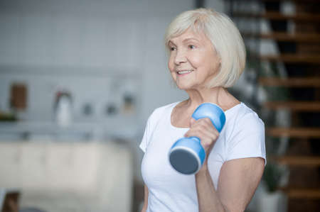 Short-haired senior woman exercising with dumbbellsの写真素材