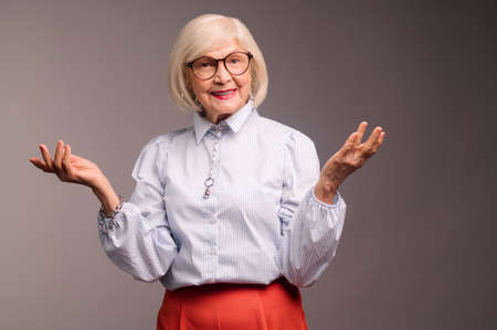 Stylish senior woman in white blouse looking confident